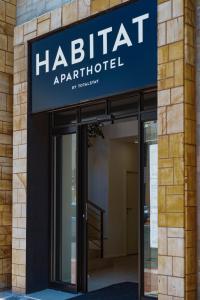 a building with a blue sign on the front of a building at Habitat Aparthotel by Totalstay in Cape Town