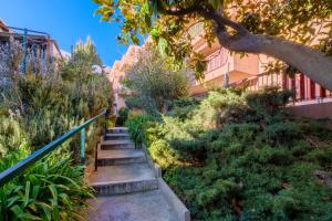 Studio verdoyant et calme في نيس: مجموعة من السلالم في حديقة بها نباتات