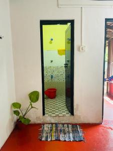 un bagno con specchio e pianta in una stanza di The Blues a Alleppey