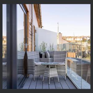 a patio with a table and chairs on a balcony at Uno St Ives - Luxury Serviced Accommodation in St Ives