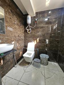 a bathroom with a toilet and a sink at HOTEL R K VILLA in Ahmedabad