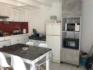 a kitchen with white appliances and a table with chairs at Appartement duplex - 2701 in Soulac-sur-Mer