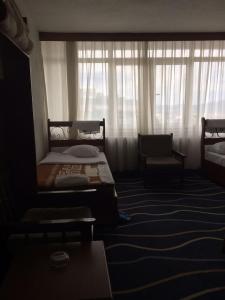 a bedroom with a bed and a window with curtains at KAYAPALI OTEL in Bursa