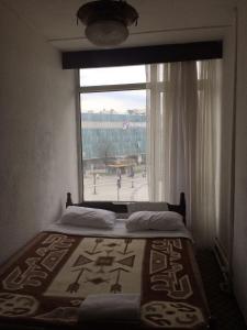 a bed in a room with a large window at KAYAPALI OTEL in Bursa