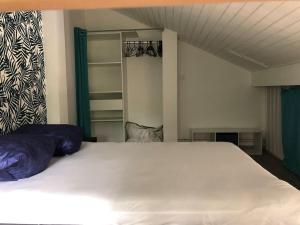 a bedroom with a large white bed with blue pillows at Appartement duplex - 2701 in Soulac-sur-Mer