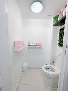 a white bathroom with a toilet and a light at Appartement proche stade de France et métro 12 in Saint-Denis