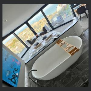 a large bath tub in a room with windows at Uno - St Ives in St Ives