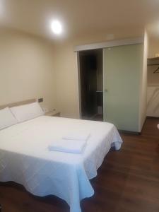 a large white bed in a room with a door at Albergue O Corisco in Redondela