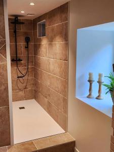 een douche in een badkamer met een tegelwand bij Ti Ar Kalon, maison proche de Quimper in Landudal