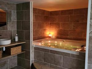 ein Bad mit einer Badewanne in einem Zimmer in der Unterkunft Ti Ar Kalon, maison proche de Quimper in Landudal