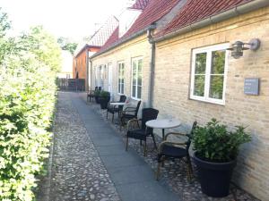 a patio with tables and chairs next to a building at Brødremenighedens Hotel in Christiansfeld