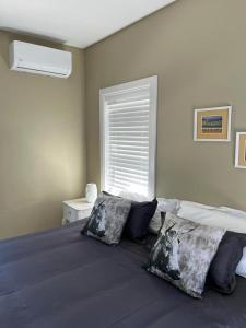 a bedroom with a bed with pillows and a window at Modern city townhouse with rooftop terrace in Cape Town