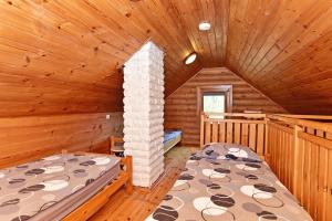 a bedroom with two beds in a log cabin at Resort by Nava Lake in Aukštadvaris