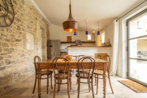 une cuisine avec une table et des chaises en bois dans l'établissement Le Petit Mas, à Belvézet