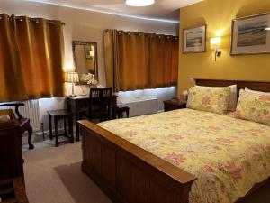 a bedroom with a bed and a desk and a table at The Old Posthouse B&B in Caenby