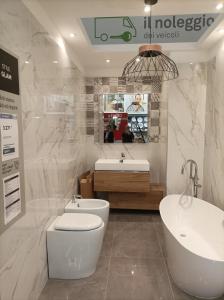 łazienka z toaletą, umywalką i wanną w obiekcie Signorile appartamento in condominio Rallo w mieście Palermo