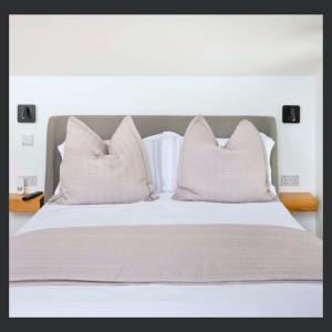 a bed with white pillows on top of it at Uno St Ives - Luxury Serviced Accommodation in St Ives