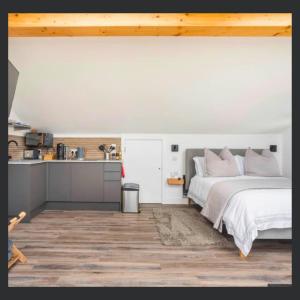 a bedroom with a bed and a kitchen at Uno St Ives - Luxury Serviced Accommodation in St Ives