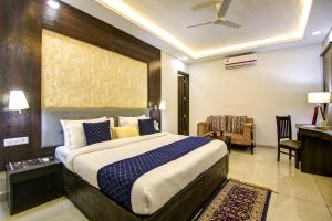 a bedroom with a large bed and a desk at Hotel Park Tree - IGI Airport A UNIT Of PRITHVI PALACE in New Delhi