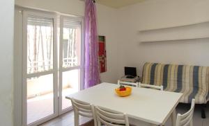 een eetkamer met een tafel en stoelen en een raam bij Modern one bedroom flat in Bibione - Beahost in Bibione