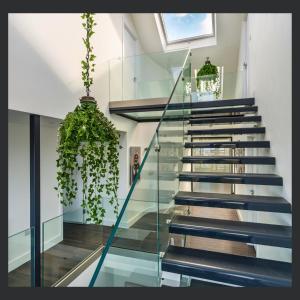 a glass staircase in a house with plants at Uno St Ives - Luxury Serviced Accommodation in St Ives