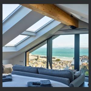a living room with blue couches and a view of the ocean at Uno St Ives - Luxury Serviced Accommodation in St Ives