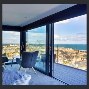a bedroom with a large window with a view of the ocean at Uno - St Ives in St Ives