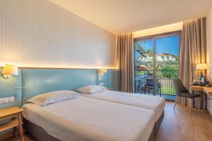 a hotel room with a large bed and a balcony at Sentido Galomar - Adults Only in Caniço