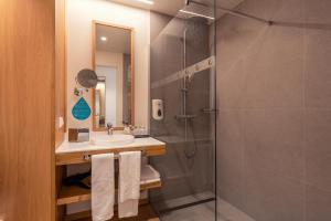 La salle de bains est pourvue d'une douche et d'un lavabo. dans l'établissement Sentido Galomar - Adults Only, à Caniço