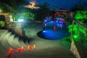 Turtle CoveにあるKokomo Botanical Resort - Caribbean Family Cottagesの赤い照明付きの夜のスイミングプール