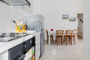 a kitchen with a refrigerator and a table with chairs at Villa Torre Guaceto by Typney in Carovigno