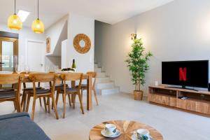 ein Wohnzimmer mit einem TV, einem Tisch und Stühlen in der Unterkunft rentafive Gran casa reformada Terraza in Santa Pola