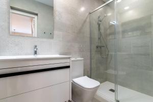 a bathroom with a toilet and a glass shower at rentafive - Gran casa reformada - Terraza in Santa Pola +32 photos