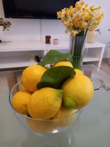 een kom citroenen op een tafel met een vaas met bloemen bij Citrus dream apartment in Athene +11 foto's