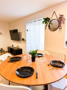 a wooden table with plates and glasses on it at *NEW*_ L'Industriel Chic au cœur de Ville _ in Guingamp +20 photos