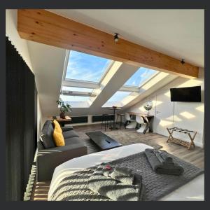 a attic room with a bed and a couch at Uno St Ives - Luxury Serviced Accommodation in St Ives