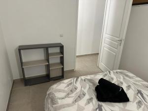 ein Schlafzimmer mit einem Bett mit einem schwarzen Kissen darauf in der Unterkunft T2 GRESY SUR ISERE in Grésy-sur-Isère