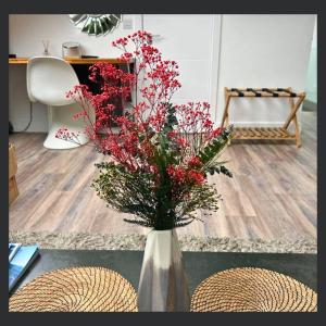 a vase with red flowers sitting on a table at Uno St Ives - Luxury Serviced Accommodation in St Ives