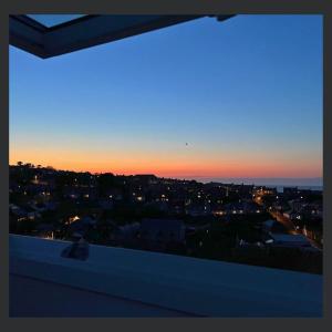 a view of a city at sunset from a balcony at Uno St Ives - Luxury Serviced Accommodation in St Ives
