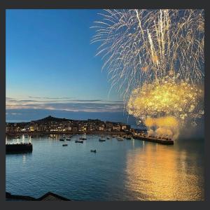 a fireworks display over a harbor with boats in the water at Uno St Ives - Luxury Serviced Accommodation in St Ives