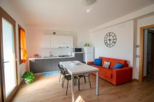 a living room with a table and a red couch at Ca' dei Berici - Relax tra Colli e città d'arte in Grancare