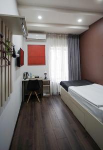 Dormitorio con cama, escritorio y cama en Elysium Gallery Hotel, en Ereván