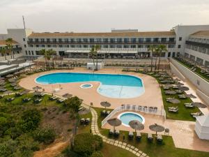 an overhead view of a resort pool with chairs and umbrellas at Ilunion Calas de Conil in Conil de la Frontera