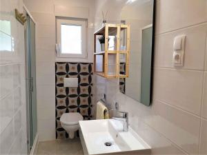 a bathroom with a sink and a toilet and a mirror at Apartment in Crikvenica 5493 in Crikvenica