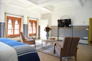 a bedroom with a table and chairs and a tv at RIAD TANJA by chef Moha in Tangier