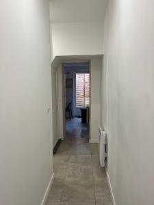 a hallway with white walls and a tile floor at Gîte le charme citadin 55 m² avec extérieur in Valenciennes