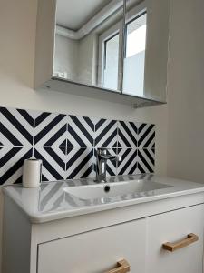 La salle de bains est pourvue d'un lavabo et d'un miroir. dans l'établissement Gîte le charme citadin 55 m² avec extérieur, à Valenciennes