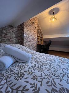 a bedroom with a bed and a brick wall at Gîte le charme citadin 55 m² avec extérieur in Valenciennes