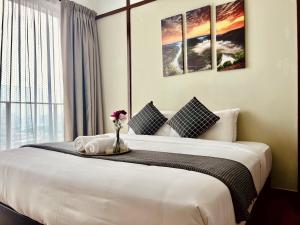 um quarto com uma cama com um vaso de flores em Vesta Home @ Silverscape Residence Melaka em Malaca