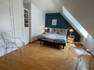 - une chambre mansardée avec un lit et deux chaises dans l'établissement Gîte Guérande, 5 pièces, 7 personnes - FR-1-306-1156, à Guérande